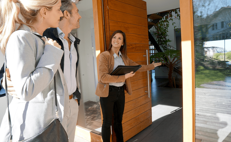 Real estate agent showing couple a new home for sale