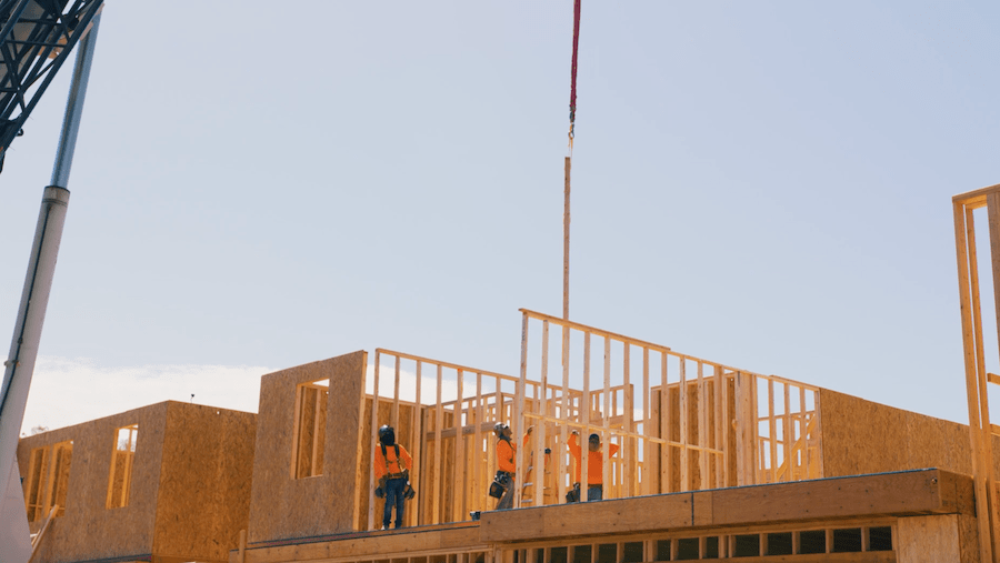 Crane lowers prefab wall panels for second floor into place on the Agorus and Hallmark Communities' Daybreak project