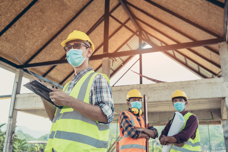 construction workers wearing protective masks against COVID-19