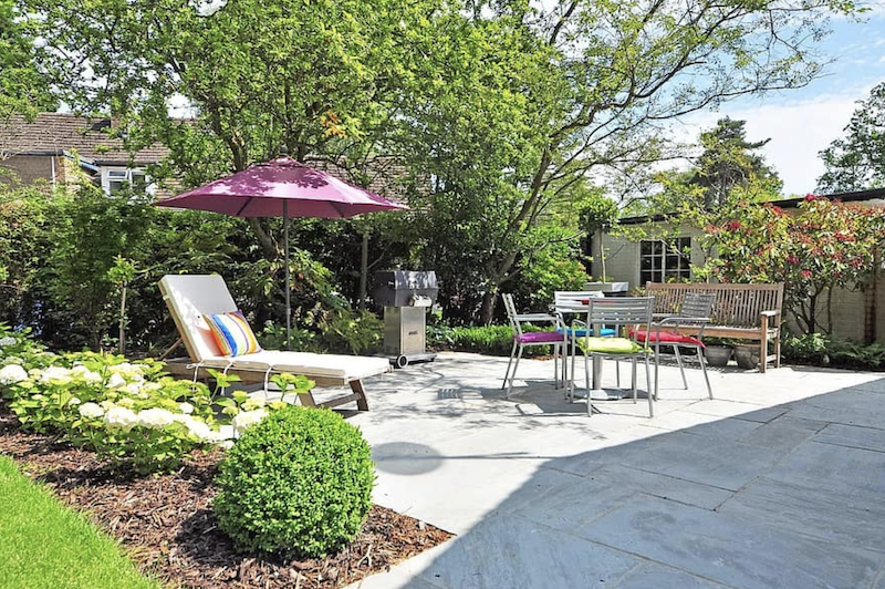 Hardscaped patio area with umbrella and seating