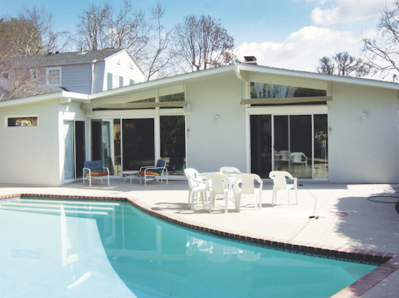 1960s home exterior with pool and fireplace before remodeling