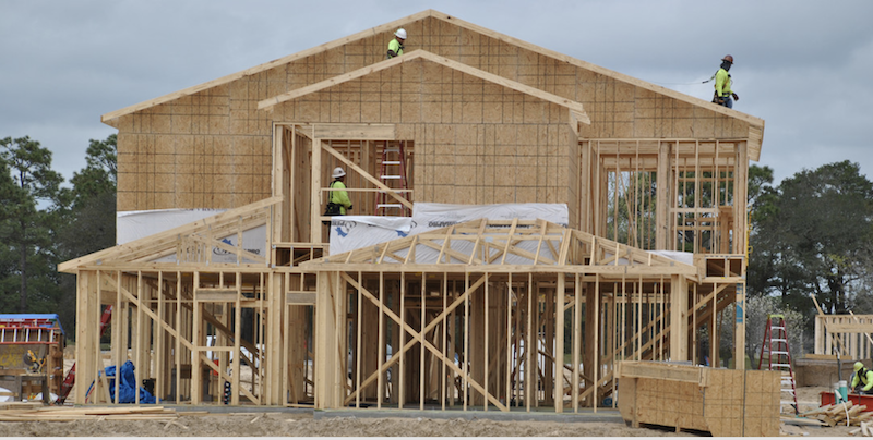 single-family house being framed using timber framing