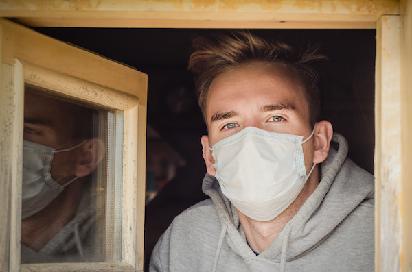 Man opening a window with mask