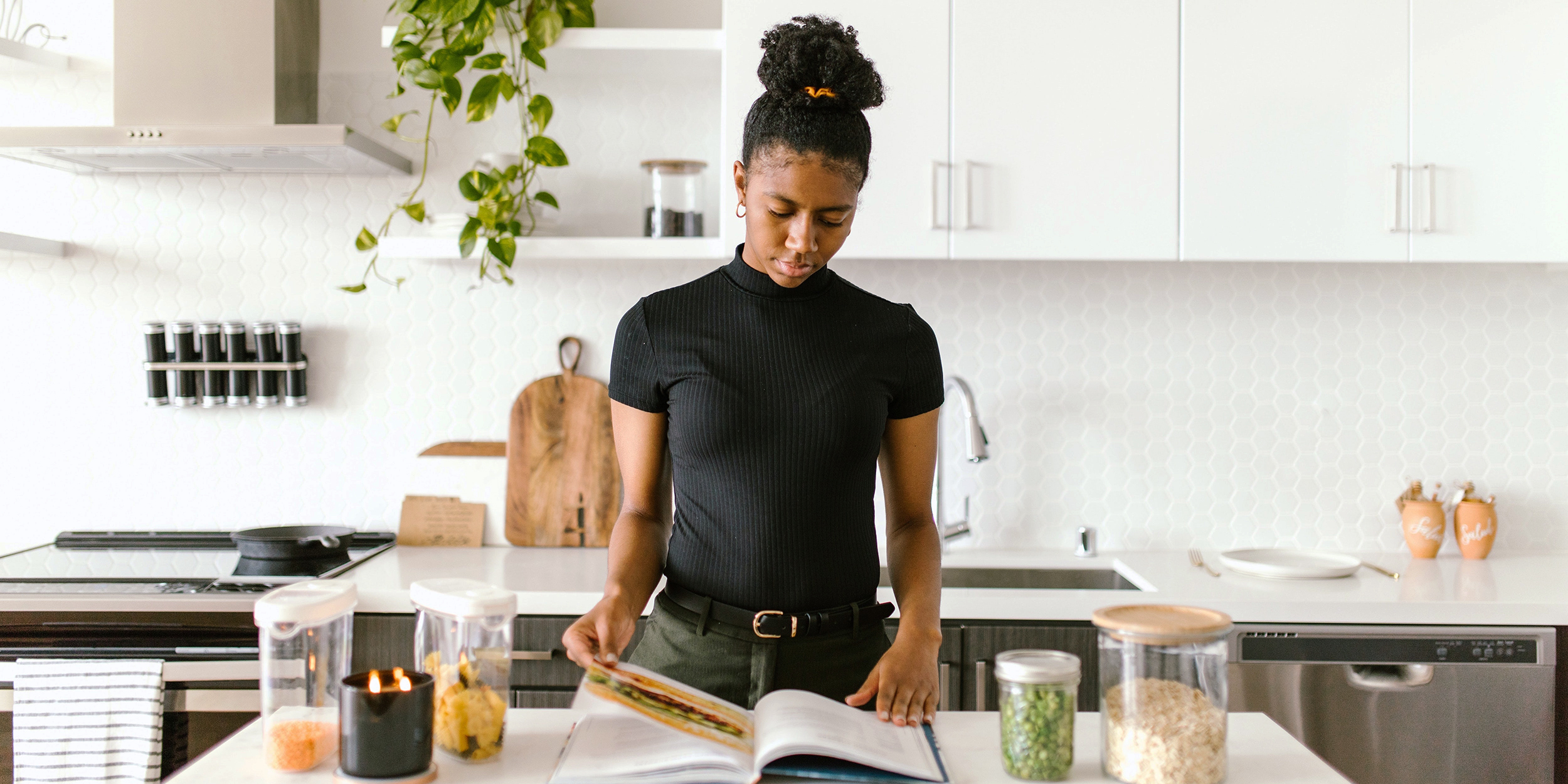 Woman in modern clean kitchen reading on island