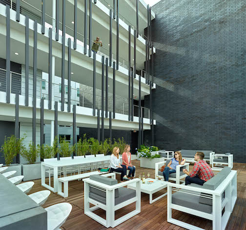 Courtyard of apartment building, small group of people talking