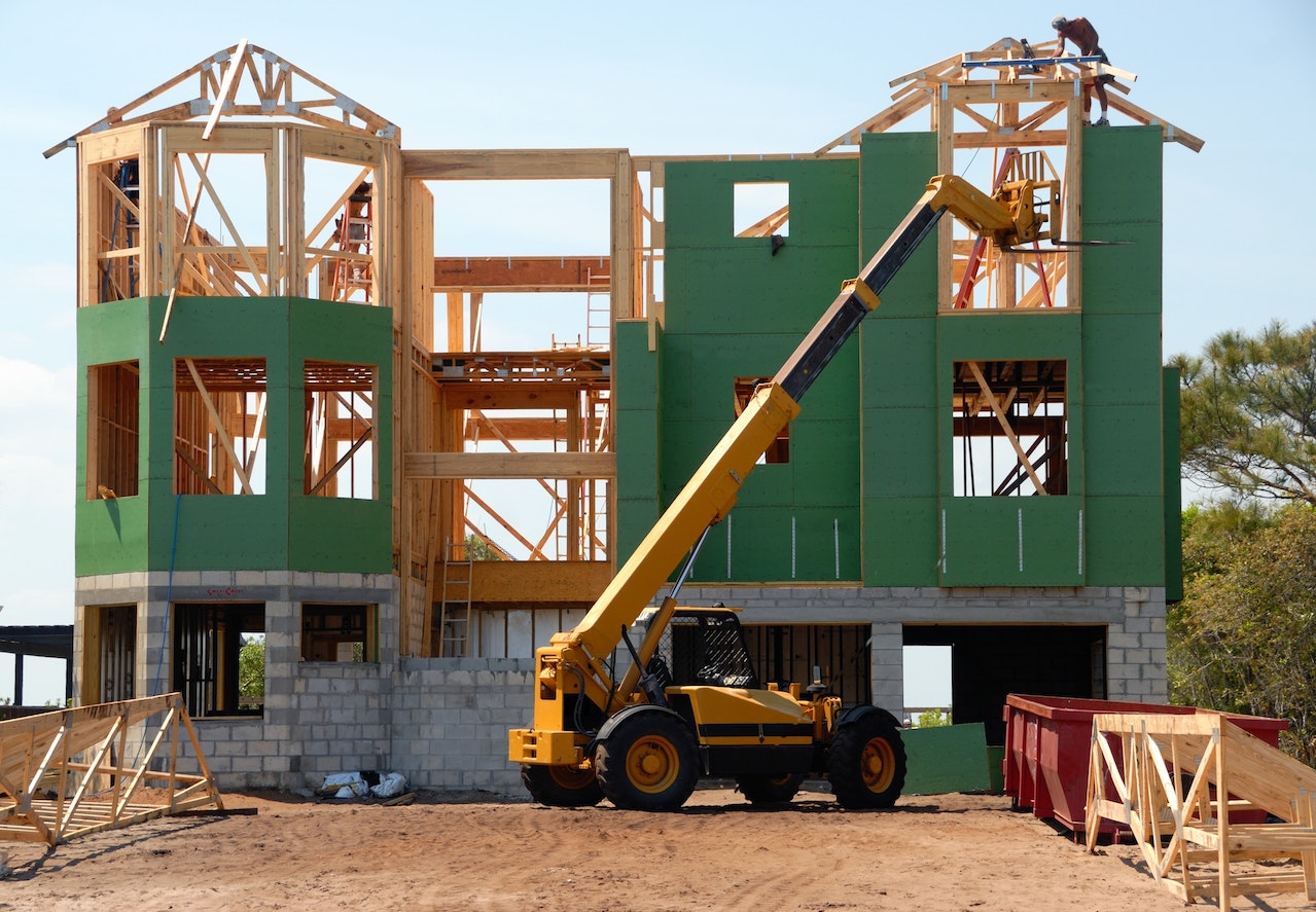 Yellow and Black Heavy Equipment Near Unfinished Building