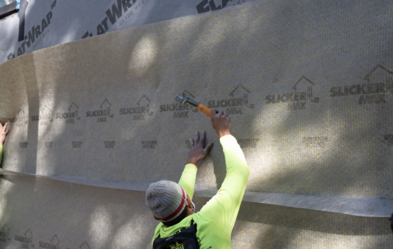 SYMBI’s siding installers tack the Slicker MAX rainscreen to the FlatWrap