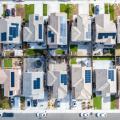 Aerial view of a row of single-family homes with solar panels on the roof