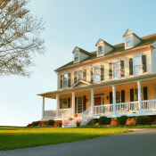 Traditional home exterior with a porch, pitched roof, and window shutters