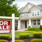 For Sale sign in front yard of house as Wall Street hedge funds buy single-family homes