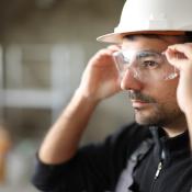 A construction worker puts on safety goggles.