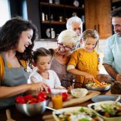 A family cooks together at a kitchen island