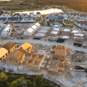 Aerial view of a community of new single-family homes at different stages of construction