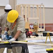 Students in hard hats work on a construction project at school