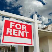 A single-family home with a "For Rent" sign in the front yard