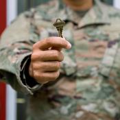 A man in a U.S. Army uniform holds up a key to a new home