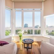 Naturally lit living room in high-rise building with city view