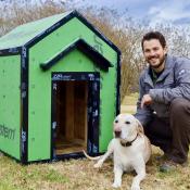 Homebuilder posing with dog in front of doghouse made from Zip tape