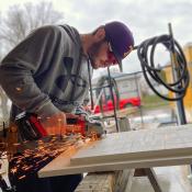 Student cutting wood for residential house construction