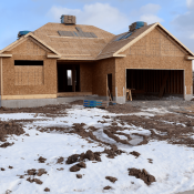 Home under construction in cold climate with snow on the ground