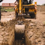 Crane digging into dirt on housing site