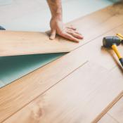 Person pulling up hardwood floor 