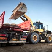 Bucket loader loading dirt into a dump truck on a construction jobsite