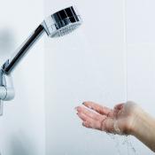 Hand under water flowing from showerhead