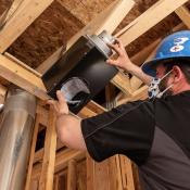 Ventilation fan being installed in ceiling