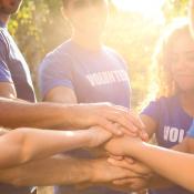 Volunteers standing with hands together