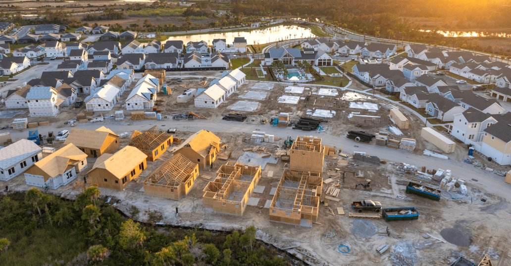 Aerial view of a community of new single-family homes at different stages of construction