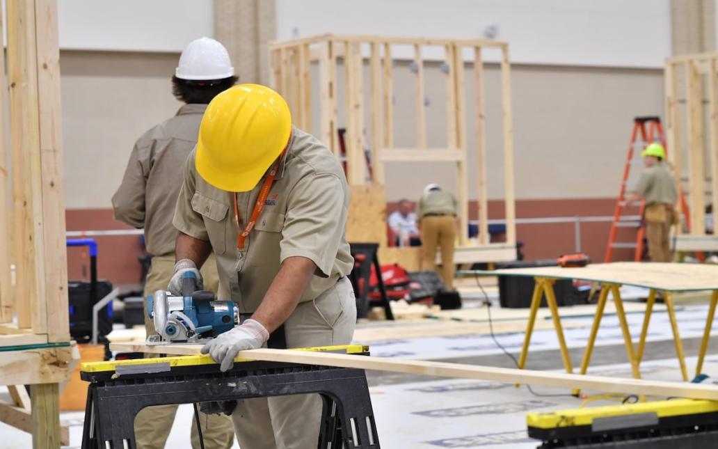 Students in hard hats work on a construction project at school