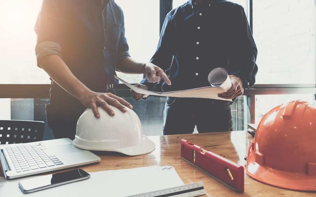 Two construction workers go over plans 