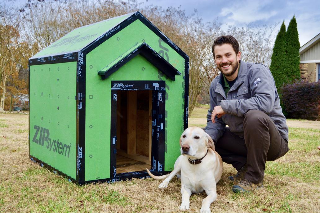 Homebuilder posing with dog in front of doghouse made from Zip tape