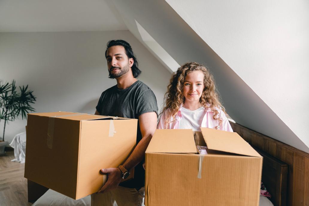 Happy couple unpacking boxes in new home