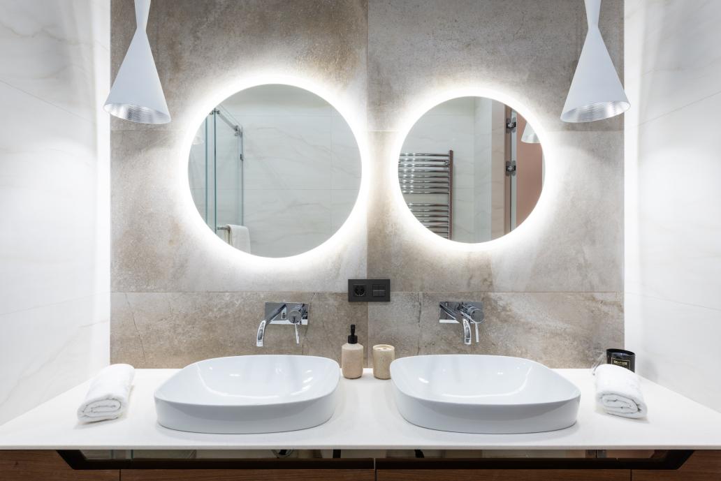 Twin bathroom mirrors with lighting around the back