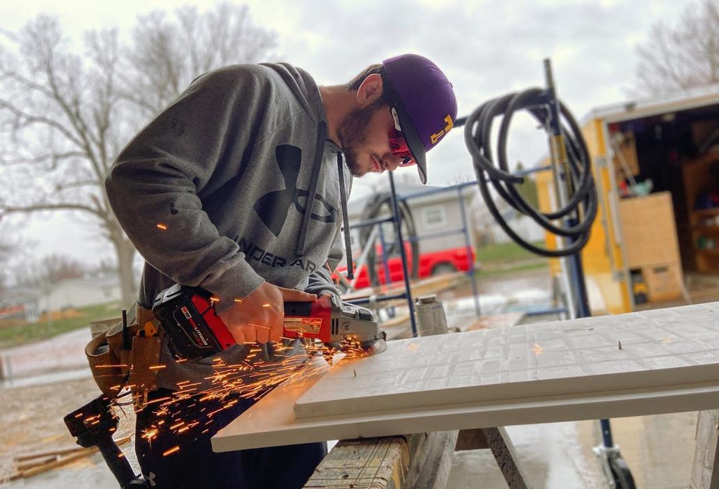 Student cutting wood for residential house construction