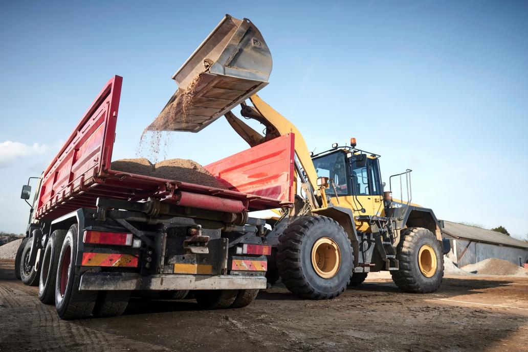 Bucket loader loading dirt into a dump truck on a construction jobsite