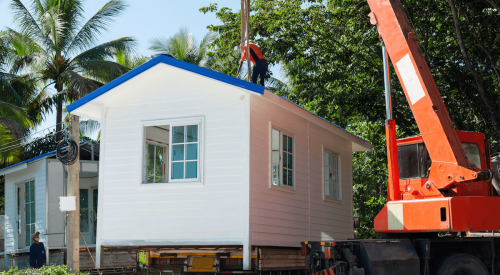 Manufactured home being craned into place on home site