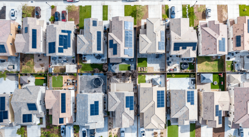 Aerial view of a row of single-family homes with solar panels on the roof