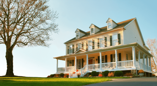 Traditional home exterior with a porch, pitched roof, and window shutters