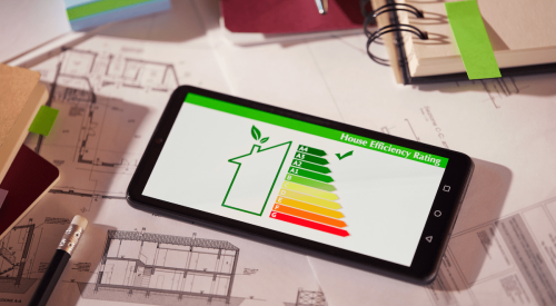 Energy-efficiency rating showing on tablet with house plans in background