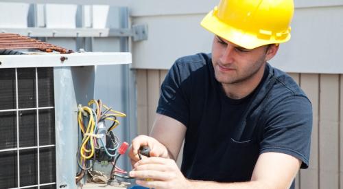 Worker fixes air conditioning unit