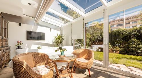 Sun room with large skylights and screen door looking out onto a landscaped backyard