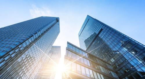 Upward view of skyscrapers against blue sky