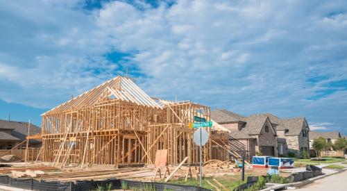 A home under construction sits at the corner of a suburban street