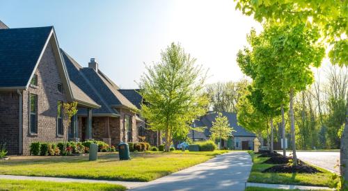 Row of brick single-family homes viewed from the sidewalk