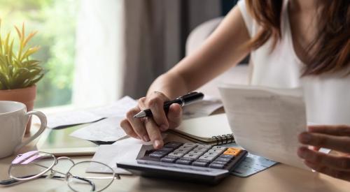 Woman sitting at table and going over bills