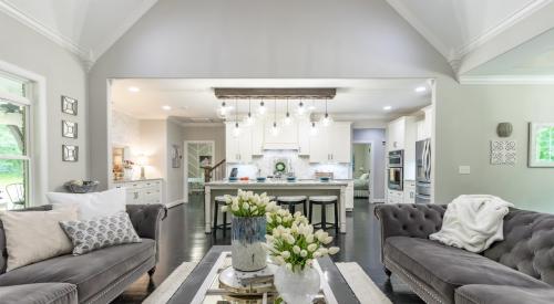 View of modern living room with newly remodeled kitchen in the background