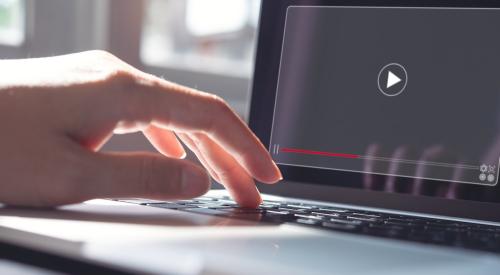 Close-up of hand pressing "play" on laptop to begin video